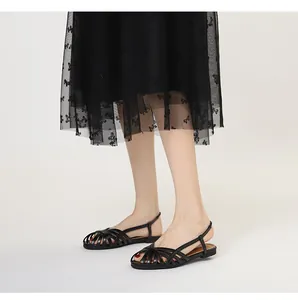 Detailansicht der schwarzen geflochtenen Gladiatorensandalen mit schmalen Riemen und Schnalle