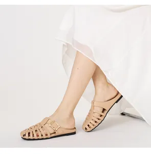 Detail of beige hollow woven flat mules with gold buckle and stylish pointed toe design