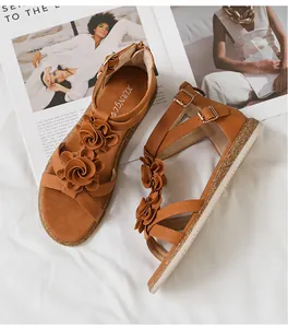 Detail of brown Roman gladiator sandals featuring 3D floral accents and metal buckle straps