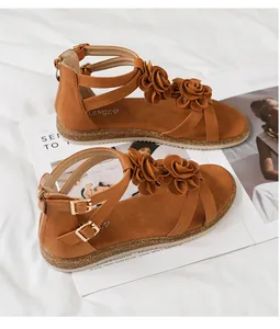 Detail of brown gladiator sandals with 3D floral accents and rear zipper closure
