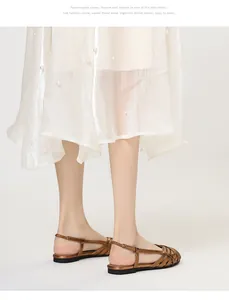 Nahaufnahme bronzefarbener Metallic-Riemchen-Sandalen kombiniert mit elegantem Rock
