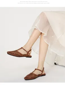 Detail der braunen Cut-Out-Sandalen mit goldenen Nieten und T-Riemen-Schnallenverschluss