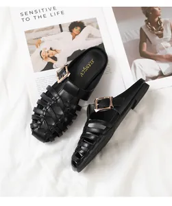 Detail of woven black leather mules featuring a stylish gold square buckle on a magazine