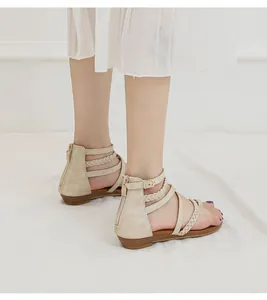 Détail de sandales compensées abricot avec brides tressées et fermeture éclair arrière