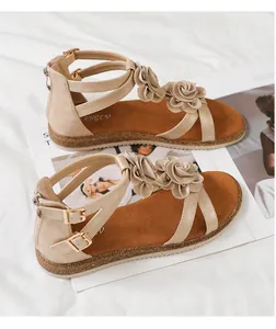 Detailed side view of beige gladiator sandals featuring 3D floral accents and zip closure