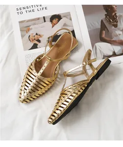 Detailansicht der goldenen Nietensandalen mit spitzer Zehenpartie und Fersenriemen