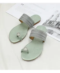 Vue détaillée des sandales plates vert clair avec anneau d'orteil en strass et brides