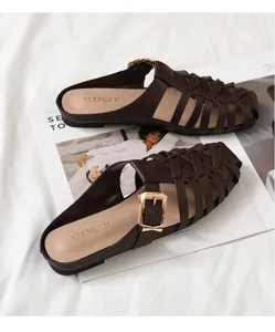 Detail of dark brown woven leather mules with gold buckle on stylish magazine background