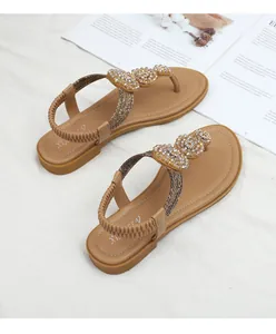 Detail of khaki bohemian sandals with heart-shaped beadwork and elastic heel strap