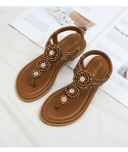 Detailed view of bohemian flip flops with intricate rhinestone flower beads and elastic strap