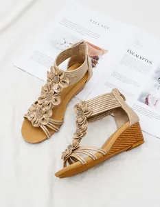 Detail of bohemian wedge sandals featuring floral embellishments and a rear zipper closure