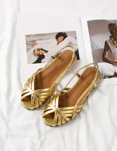 Detailansicht der flachen Sandalen in Gold-Metallic mit Kreuzriemen und weicher Sohle