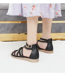 Detail view of black bohemian flat sandals with woven straps and back zipper closure