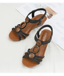 Top view of wedge sandals with black T-straps and decorative wood-grain accents