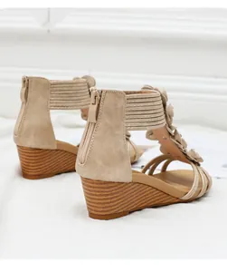 Detail of bohemian wedge sandals featuring floral accents and a rear zip closure
