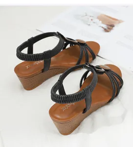 Detail of black wedge sandals with elastic heel strap and stylish wood grain platform sole