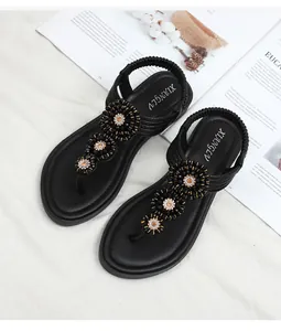 Detail of black thong sandals with beaded flowers and champagne rhinestone accents