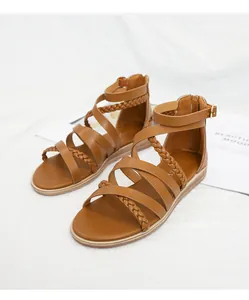 Detail of light brown gladiator sandals featuring woven leather straps and rear zipper closure