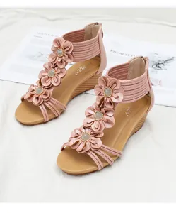 Detailed view of pink wedge sandals featuring 3D leather flowers and beaded centers