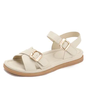 Sandali bassi da donna color crema con cinturini doppi e grandi fibbie in metallo dorato