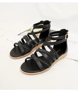 Close-up of black bohemian Roman sandals featuring braided straps and back zipper closure