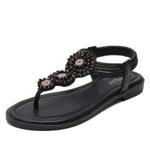 Women black bohemian flat sandals with floral beading and elastic strap for beach vacations