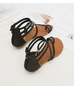 Détail de sandales noires à talon compensé avec boucle d'orteil et fermeture éclair arrière