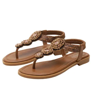 Women's brown flat bohemian sandals with beaded flower accents for beach vacation