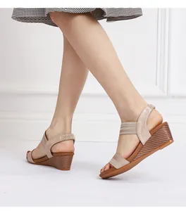 Detail of wedge sandal showing elastic straps and dark wood-textured heel on model