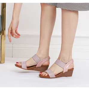 Side view of women's wedge sandals featuring pink glitter elastic straps and wood-grain soles