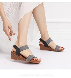 Close-up of black elastic straps and wedge heel with wood grain finish on sandals