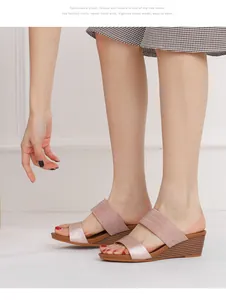 Dettaglio dei sandali con zeppa oro rosa con cinturini doppi e suola plateau effetto legno
