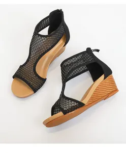 Detail van zwarte sleehak sandalen van mesh stof met strasstenen en rits achteraan