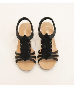 Detailed view of black wedge sandals featuring leaf-shaped ornaments and tiny rhinestones