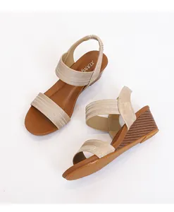 Detail of champagne gold wedge sandals featuring dual textured straps and elastic back strap