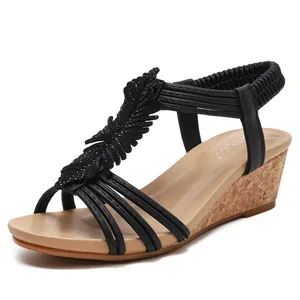 Women's wedge sandals with black feather straps and cork textured platform sole