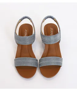 Detailed top view of light blue glitter strap sandals with brown footbed and elastic heel