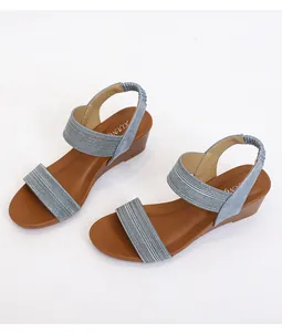 Detail view of women's wedge sandals featuring blue woven straps and a wood-textured heel