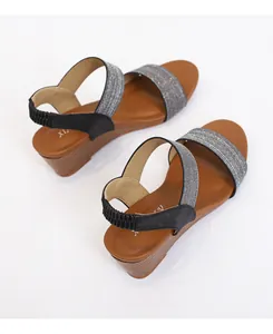 Detail of silver glitter straps and wooden wedge heel on these women's fashion sandals
