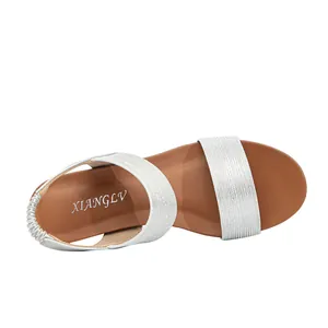 Detailed top view of silver glitter straps and brown insole of these stylish wedge sandals
