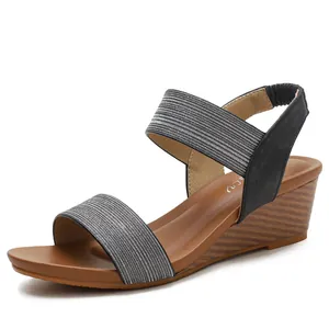 Women's wedge sandals with black elastic straps and silver stripes on a wood-textured heel
