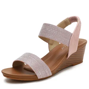 Women's pink wedge sandals with glittery fabric straps and wood-textured platform heels