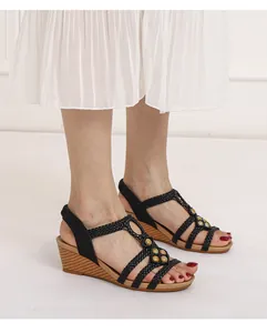 Detalle de sandalias bohemias con cuña, correas tejidas y cuentas de colores vintage
