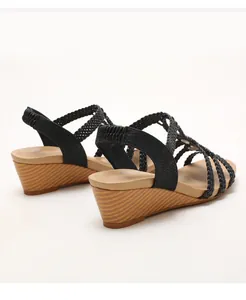 Detalle de tiras trenzadas y cuña con efecto de madera en sandalias negras bohemias