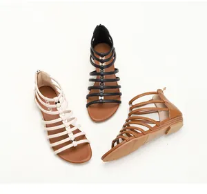 Detailed view of gladiator sandals in white, black and brown with golden bows decoration