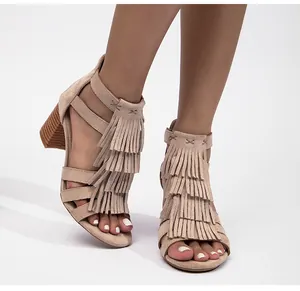 Detalle de flecos beige y textura de ante en las sandalias de tacón ancho para mujer