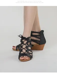 Details schwarzer Keilsandaletten mit Cut-outs, Schnürung und metallischem Reißverschluss
