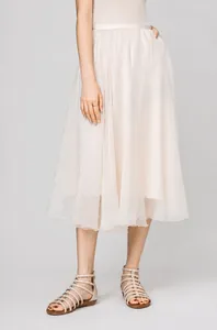 Detail of beige gladiator sandals with metallic studs styled with a long pleated skirt