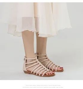 Detail of beige gladiator sandals featuring gold butterfly accents and rear zipper closure