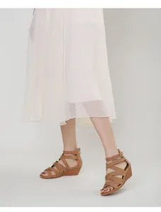 Detail of brown wedge sandals with crisscross straps and a matte finish for casual style